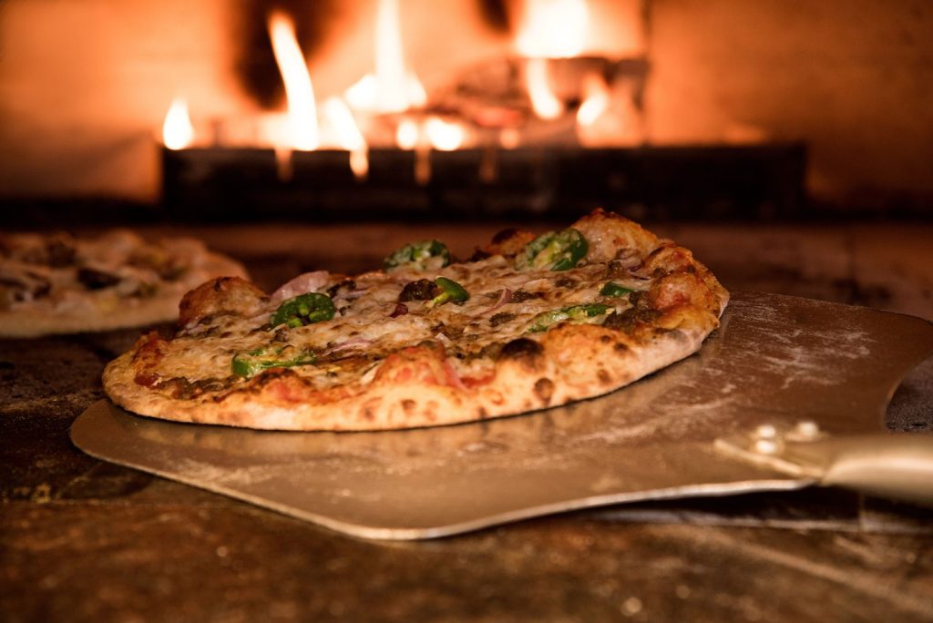 Pizza recién horneada en horno de leña