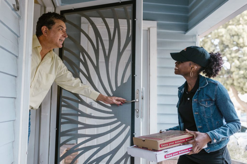 Repartidora entregando cajas de pizza a domicilio