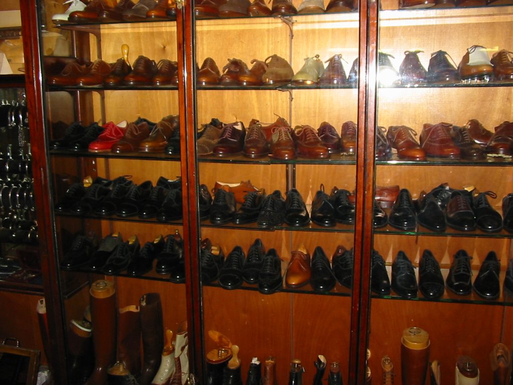 Vitrina de zapatería con estantes llenos de zapatos de vestir