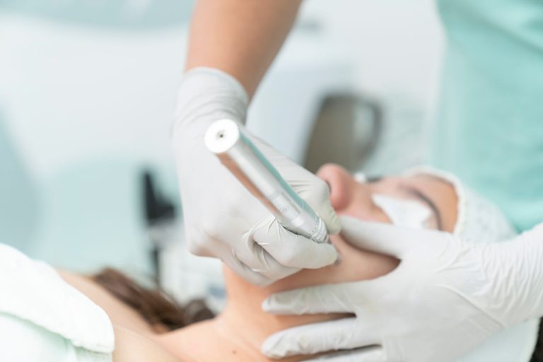 Esteticista aplicando un tratamiento facial con un dispositivo profesional